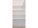 Bright and airy walk-in closet features all-white walls and built-in shelving at 211 80Th N Ave, St Petersburg, FL 33702