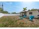 Backyard with a fire pit, adirondack chairs, a white fence, and a grill under the patio at 2153 Pocahontas Dr, Largo, FL 33774
