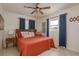 Cozy bedroom with neutral walls, modern ceiling fan, and natural lighting featuring an orange comforter at 2153 Pocahontas Dr, Largo, FL 33774