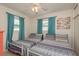Bedroom with dual beds, matching patterned bedding, ceiling fan with light, and bright curtains at 2153 Pocahontas Dr, Largo, FL 33774