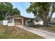 Inviting single-story home with a well-maintained lawn, private drive, and quaint outdoor seating at 2153 Pocahontas Dr, Largo, FL 33774
