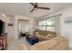 Bright living room with neutral walls, a large mirror, and comfortable tan sofas beneath a modern ceiling fan at 2153 Pocahontas Dr, Largo, FL 33774