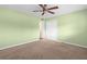 Green bedroom with neutral carpeting, ceiling fan, and a double door closet at 2228 Swedish Dr # 22, Clearwater, FL 33763