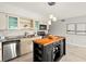 Well-lit kitchen featuring stainless steel appliances, a black butcher block island, and cream colored cabinetry at 2228 Swedish Dr # 22, Clearwater, FL 33763