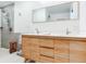 Modern bathroom features a double vanity, wood cabinets, gray tile shower, and tile flooring at 246 22Nd Ne Ave, St Petersburg, FL 33704