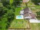 Aerial view of a home with an in-ground pool, wooden fence, and lush landscaping at 2512 Rustic Oaks Dr, Lutz, FL 33559