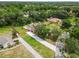 Aerial shot showcases a home with a pool, mature trees, and a long driveway at 2512 Rustic Oaks Dr, Lutz, FL 33559