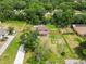 Aerial view of a two-story home with a spacious yard, pool, and lush landscaping at 2512 Rustic Oaks Dr, Lutz, FL 33559
