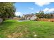 Backyard with a well-maintained lawn, mature trees, and a view of the pool and outdoor entertaining space at 2512 Rustic Oaks Dr, Lutz, FL 33559