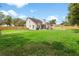 Expansive backyard featuring a well-maintained lawn, pool, covered patio, and a wooden privacy fence at 2512 Rustic Oaks Dr, Lutz, FL 33559