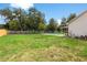 Spacious backyard featuring a refreshing pool, green lawn, and a privacy fence at 2512 Rustic Oaks Dr, Lutz, FL 33559