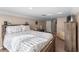 Bright bedroom with a floral bed spread, beige carpet and walls, and a dark wooden bed frame at 2512 Rustic Oaks Dr, Lutz, FL 33559