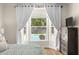Cozy bedroom offers a view of the backyard pool and has curtains on the large window at 2512 Rustic Oaks Dr, Lutz, FL 33559