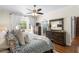 Sunlit bedroom features hardwood floors, a ceiling fan, backyard view, and stylish décor at 2512 Rustic Oaks Dr, Lutz, FL 33559