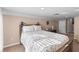Bright bedroom with a floral bed spread, beige carpet and walls, and a dark wooden bed frame at 2512 Rustic Oaks Dr, Lutz, FL 33559