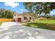 View of the home showcasing the garage, driveway, and landscaped yard at 2512 Rustic Oaks Dr, Lutz, FL 33559