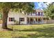 Beautiful two-story home with a large front yard featuring mature trees and a charming swing at 2512 Rustic Oaks Dr, Lutz, FL 33559