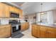 Modern kitchen with stainless steel oven and granite countertops, open to dining area at 2512 Rustic Oaks Dr, Lutz, FL 33559