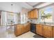 Well-lit kitchen featuring granite countertops, wood cabinets, and modern appliances at 2512 Rustic Oaks Dr, Lutz, FL 33559