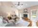 Inviting living room with wood floors, fireplace, ceiling fan, and doors leading to outdoor areas at 2512 Rustic Oaks Dr, Lutz, FL 33559
