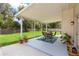 Relaxing covered patio with an outdoor dining set, plants, and a view of the spacious backyard at 2512 Rustic Oaks Dr, Lutz, FL 33559