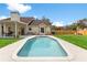 Beautiful pool with a patio, surrounded by a landscaped yard and a charming home at 2512 Rustic Oaks Dr, Lutz, FL 33559