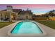 Tranquil pool with surrounding patio and lovely outdoor setting against a colorful sunset sky at 2512 Rustic Oaks Dr, Lutz, FL 33559