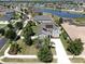 Beautiful aerial view of a gray two-story home with a long driveway, solar panels, and a lake view at 2517 Cumberland Cliff Dr, Ruskin, FL 33570