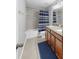 Bathroom with tile floors, double sink with wood cabinets, tub and shower combination with blue striped curtain at 2517 Cumberland Cliff Dr, Ruskin, FL 33570
