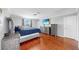 Comfortable bedroom with wood floors, large windows, a bed with stylish gray bedding, and an entertainment center at 2517 Cumberland Cliff Dr, Ruskin, FL 33570