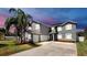 Stately two-story home with a three-car garage, manicured lawn, and mature palm trees at 2517 Cumberland Cliff Dr, Ruskin, FL 33570