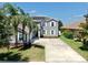 Exterior view of a well-maintained two-story gray home with a spacious driveway and lush landscaping at 2517 Cumberland Cliff Dr, Ruskin, FL 33570