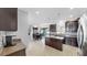 Modern kitchen features tile floors, center island, stainless steel appliances, and granite countertops at 2517 Cumberland Cliff Dr, Ruskin, FL 33570