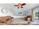Spacious living room features neutral paint, tile floors, ceiling fan, and a flat screen television at 2517 Cumberland Cliff Dr, Ruskin, FL 33570