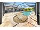 Tanning shelf leads into a larger pool, screened in and surrounded by stone pavers at 2517 Cumberland Cliff Dr, Ruskin, FL 33570