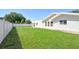 Lush green backyard surrounded by a white privacy fence and featuring a well manicured lawn at 2675 Firestone Dr, Clearwater, FL 33761