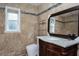 Bathroom with travertine tile, vanity with marble counter top, modern toilet and open shelving at 2675 Firestone Dr, Clearwater, FL 33761