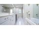 Bright bathroom featuring a double sink vanity, a soaking tub, and a walk-in shower at 2675 Firestone Dr, Clearwater, FL 33761