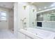 A bright bathroom with a jetted tub, separate shower, and a large mirror reflecting double sinks at 2675 Firestone Dr, Clearwater, FL 33761