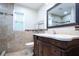 Bathroom featuring a vanity, marble countertop, decorative tile, and stylish framed mirror at 2675 Firestone Dr, Clearwater, FL 33761