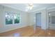 Sunlit bedroom featuring hardwood floors, a ceiling fan, windows, and mirrored closet at 2675 Firestone Dr, Clearwater, FL 33761
