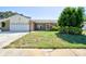 Well-maintained single-story home featuring lush landscaping, manicured lawn, and brick accents at 2675 Firestone Dr, Clearwater, FL 33761