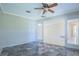 Spacious living area featuring stone floors, ceiling fan, and glass french doors to a bright airy room at 2675 Firestone Dr, Clearwater, FL 33761
