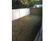 Fenced backyard area featuring a combination of white vinyl and wood privacy fencing and a patch of green grass at 3115 Winchester Dr, Dunedin, FL 34698