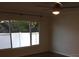 Bedroom features a ceiling fan, a large window, and hardwood floors at 3115 Winchester Dr, Dunedin, FL 34698