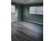Cozy bedroom with neutral walls, hardwood floors, and natural light from two windows at 3115 Winchester Dr, Dunedin, FL 34698