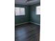 Cozy bedroom with two windows and dark gray hardwood floors at 3115 Winchester Dr, Dunedin, FL 34698