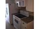 Bright kitchen featuring a white refrigerator, range, microwave, and stone countertops at 3115 Winchester Dr, Dunedin, FL 34698