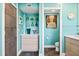 Stylish bathroom with floating vanity, aqua walls, and a decorative niche with glass vases at 3130 Walnut Ne St, St Petersburg, FL 33704
