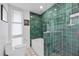 Stylish bathroom featuring green tiles, modern shower, and unique patterned floor at 3130 Walnut Ne St, St Petersburg, FL 33704